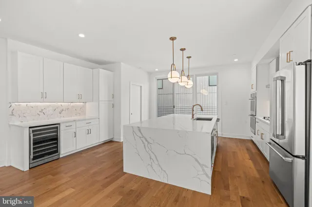 a kitchen with stainless steel appliances kitchen island a white stove top oven and wooden floor