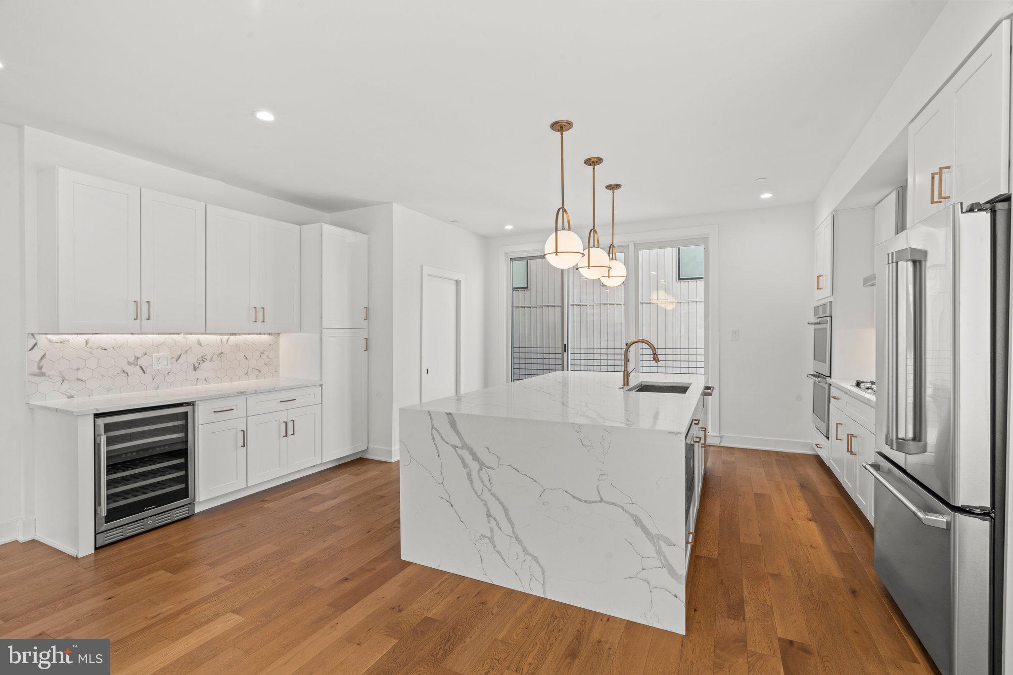 2240 League Street Philadelphia, PA 19146 - Photo 7 of 43 a large white kitchen with a stove a sink dishwasher and a refrigerator with wooden floor