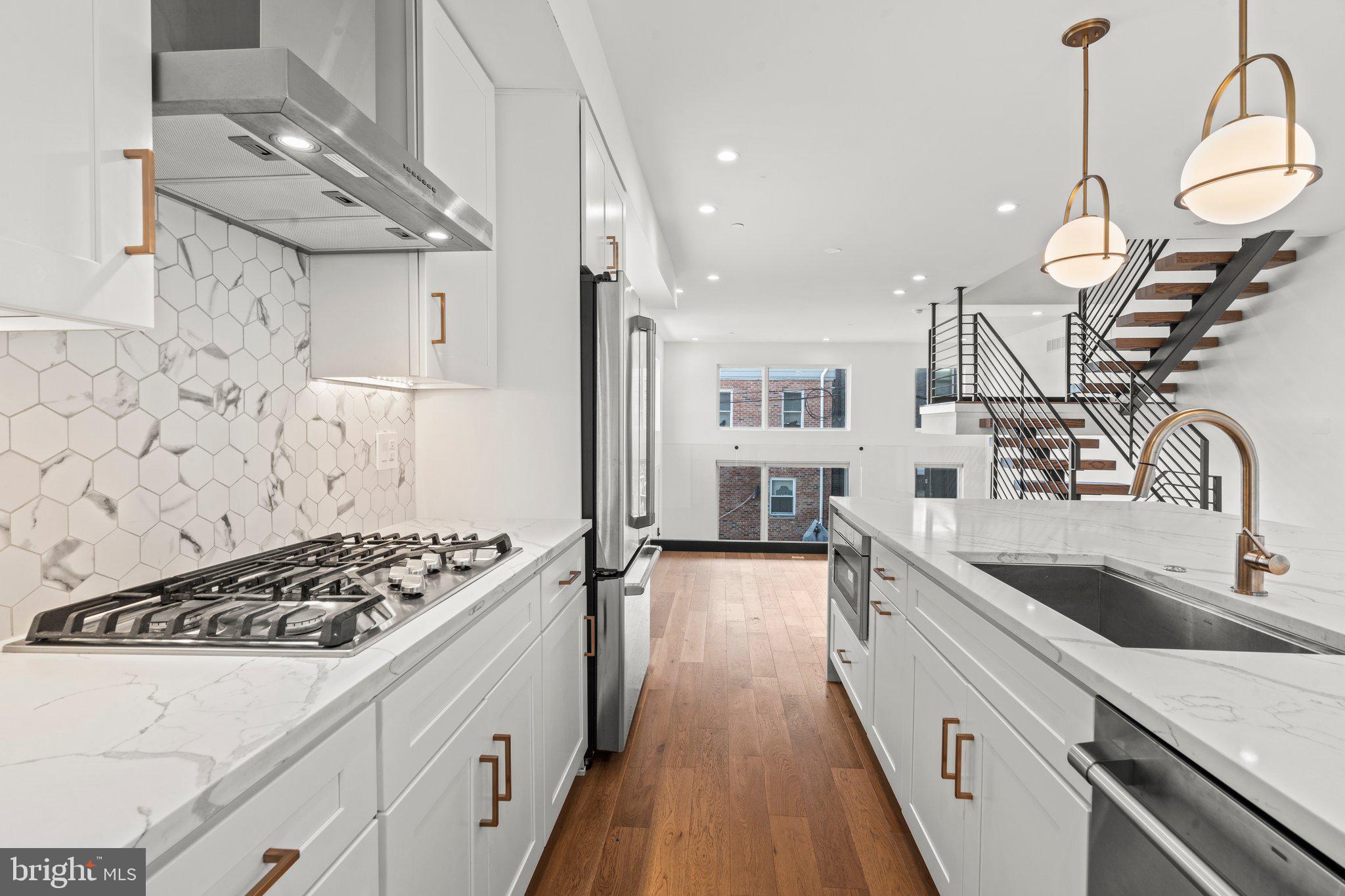 2240 League Street Philadelphia, PA 19146 - Photo 8 of 43 a kitchen with stainless steel appliances kitchen island a white stove top oven and wooden floor
