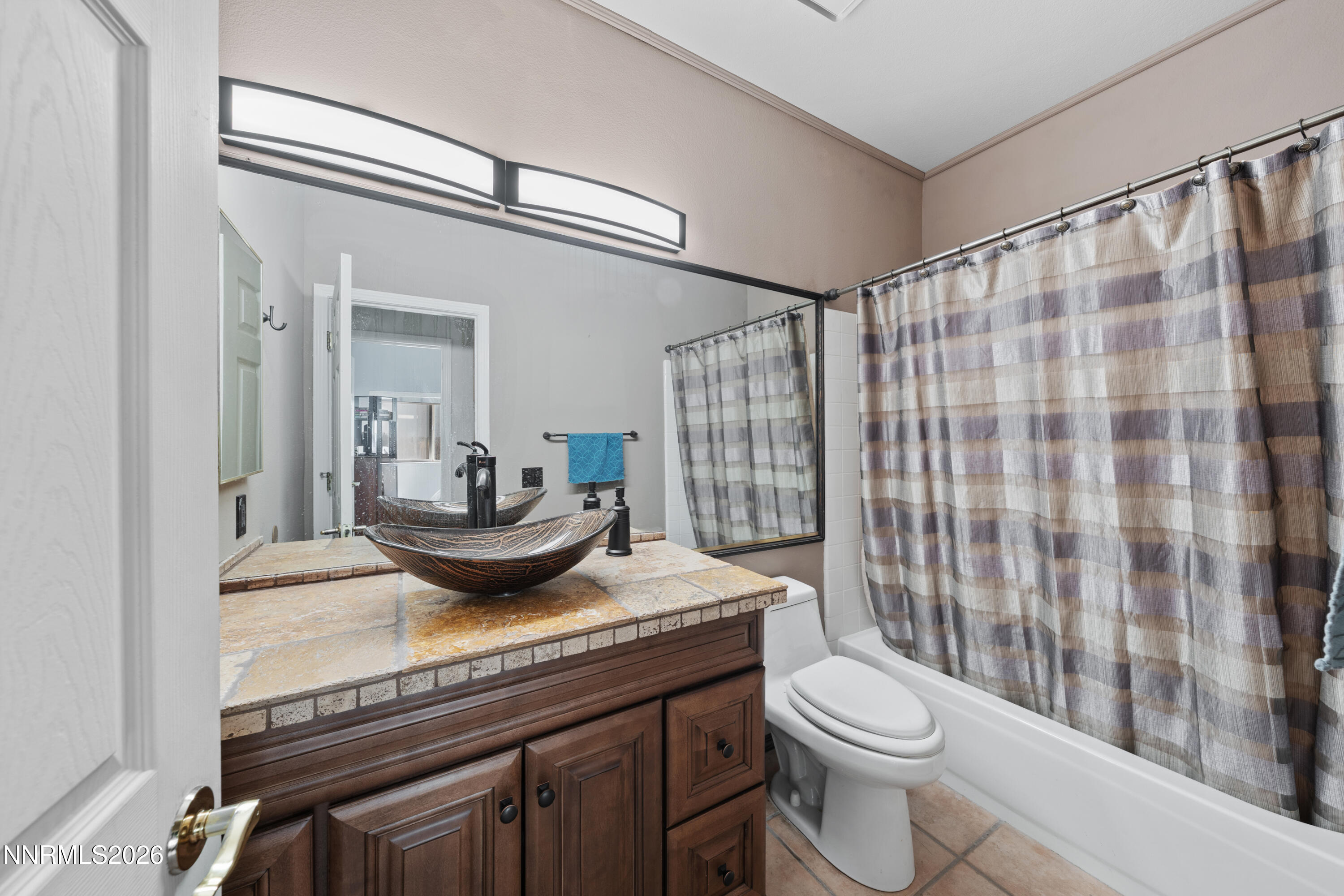 3225 Eaglewood Drive Reno, NV 89502 - Photo 21 of 45 a bathroom with a granite countertop sink a toilet a mirror and shower curtain
