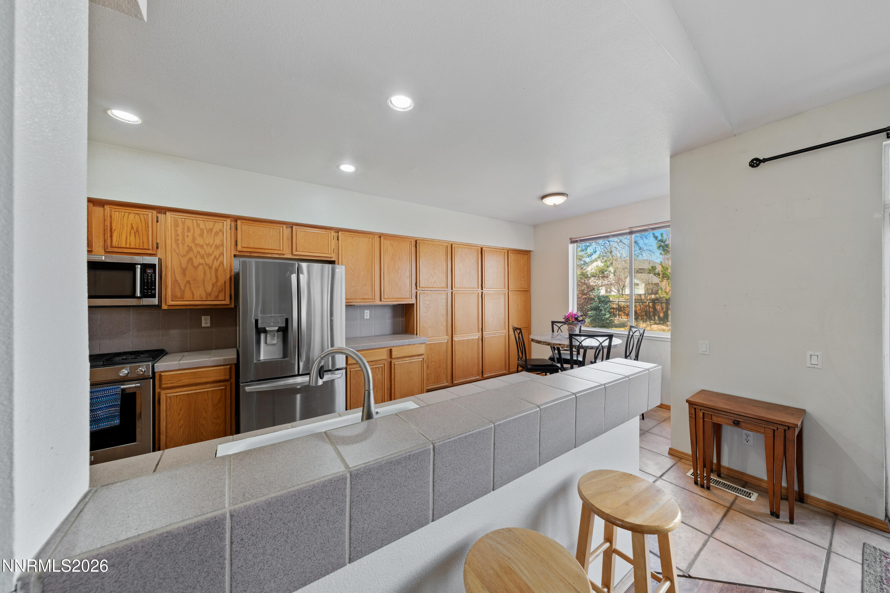 3225 Eaglewood Drive Reno, NV 89502 - Photo 9 of 45 a large kitchen with stainless steel appliances kitchen island granite countertop a refrigerator and a stove top oven with wooden floors