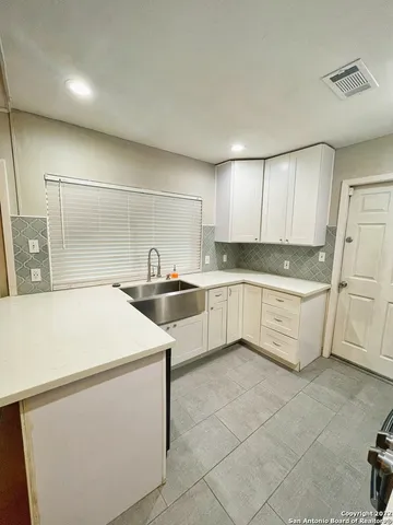 a kitchen with granite countertop white cabinets and white appliances