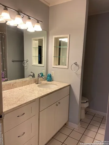 a bathroom with a granite countertop sink a toilet and a mirror