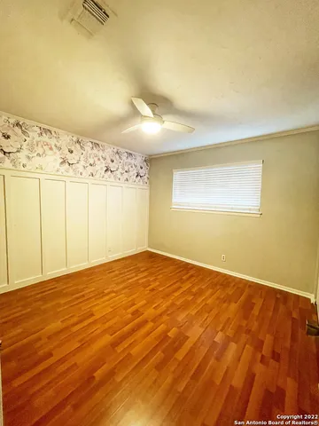 a view of empty room with wooden floor