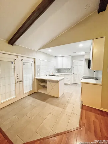 a large white kitchen with a sink and cabinets