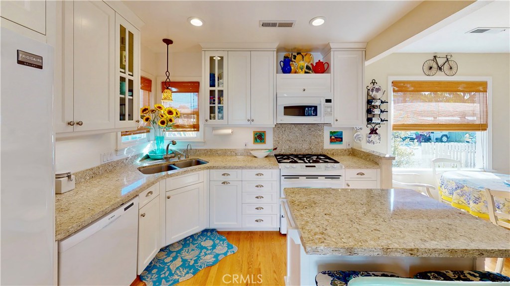 514 Middlefield Drive Aptos, CA 95003 - Photo 18 of 31 a kitchen with stainless steel appliances granite countertop a sink dishwasher and white cabinets with wooden floor