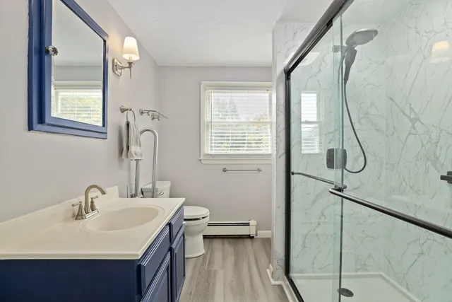 a bathroom with a sink and mirror with toilet