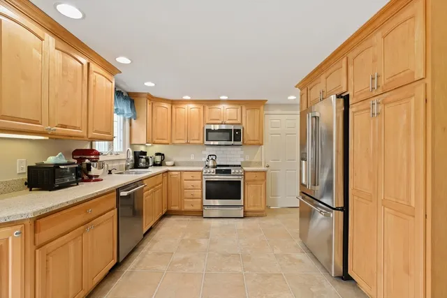 a kitchen with stainless steel appliances a refrigerator sink and cabinets