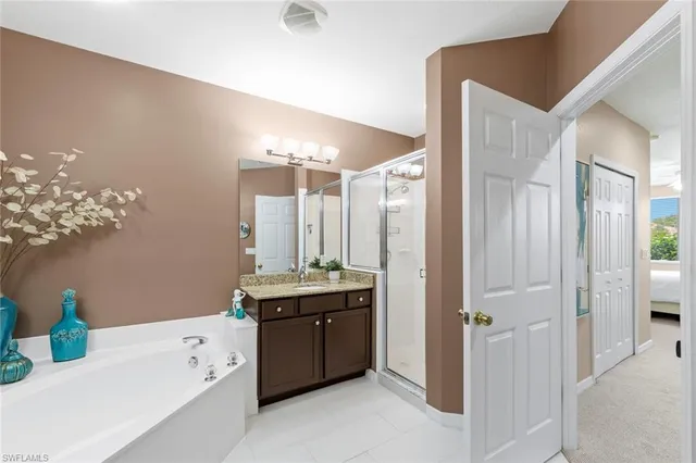 a bathroom with a double vanity sink a mirror and a bathtub