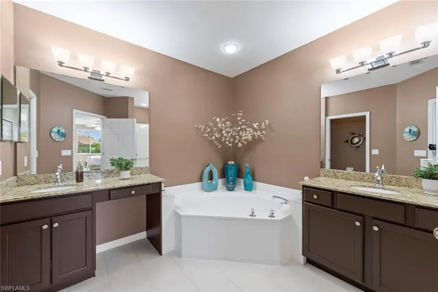 a bathroom with a sink vanity tub and a mirror