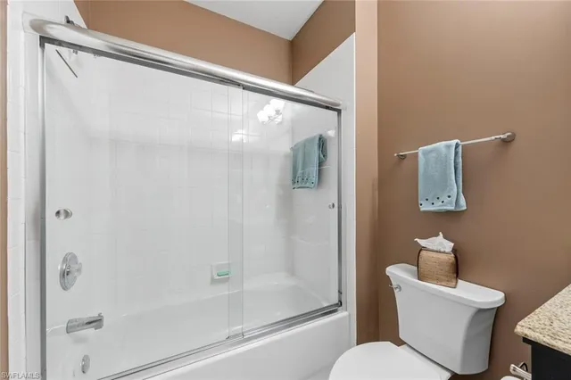 a white toilet sitting next to a bathroom sink