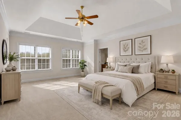 a spacious bedroom with a large bed chandelier and a window