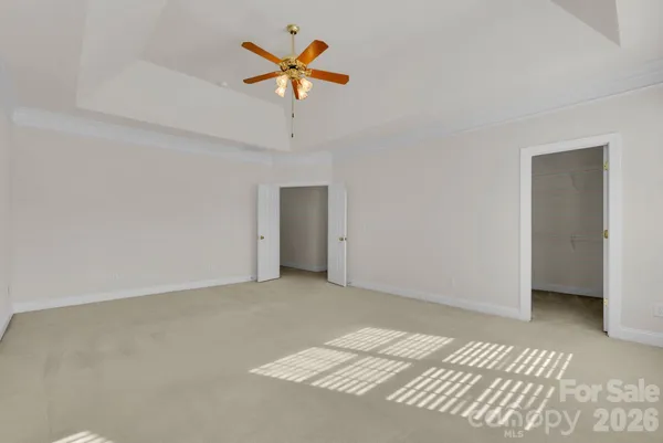 an empty room with a ceiling fan and a window