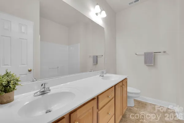 a bathroom with a sink a toilet and a mirror