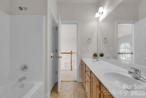 a bathroom with a granite countertop sink a mirror and a bathtub
