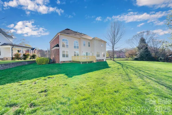 a view of a house with a big yard and large trees