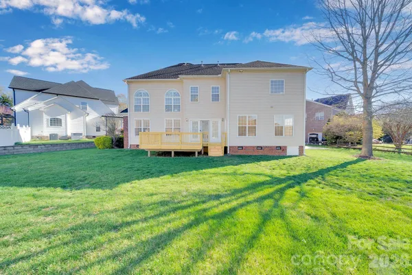 a view of a house with a big yard and large trees