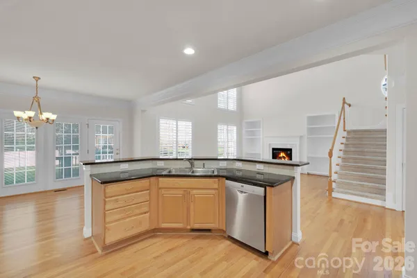 a kitchen with granite countertop kitchen island white cabinets and wooden floor