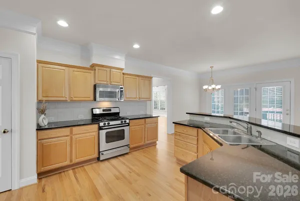 a kitchen with stainless steel appliances granite countertop a sink and wooden cabinets