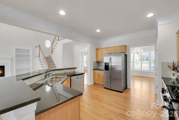 a kitchen with stainless steel appliances granite countertop a lot of counter space and wooden floor
