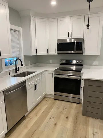 a kitchen with cabinets appliances and a sink