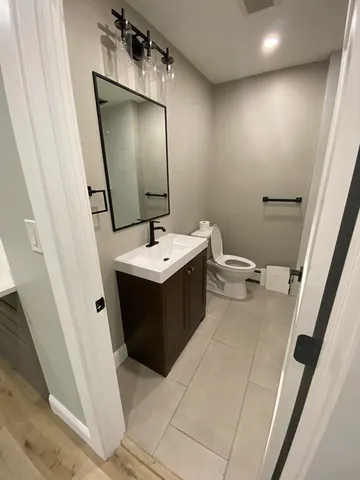 a bathroom with a sink a toilet and mirror