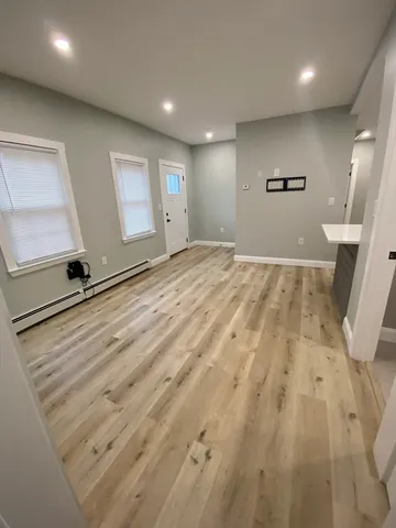 an empty room with wooden floor and mirror