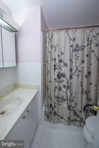 a white toilet sitting next to a shower curtain