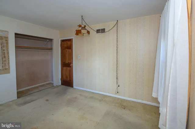 an empty room with windows and closet