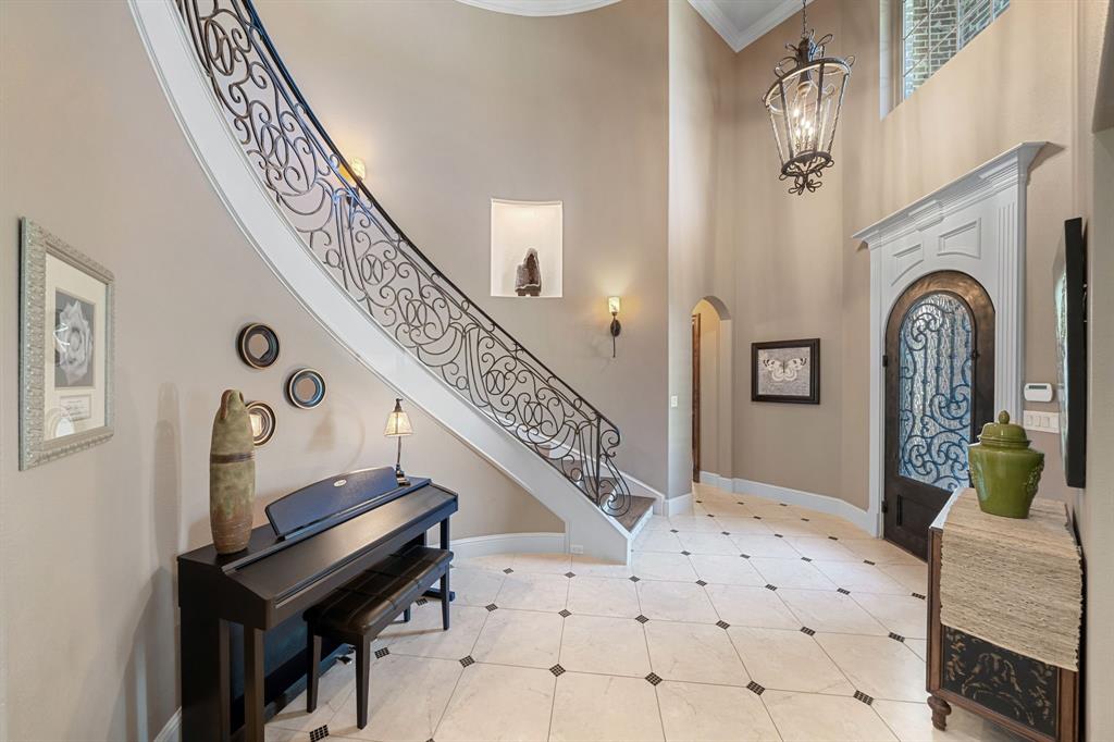 3108 Jenbri Street Flower Mound, TX 75022 - Photo 4 of 39 Enter through the arched iron door to the stunning custom curved staircase and custom designer tile flooring.