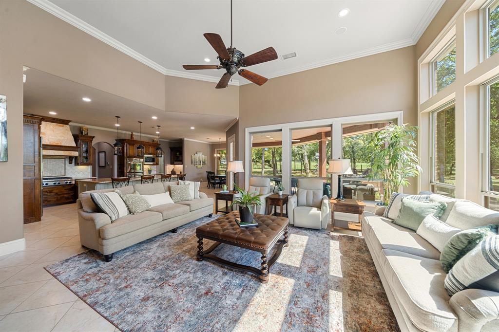 3108 Jenbri Street Flower Mound, TX 75022 - Photo 10 of 39 Windows spanning the rear of the home flood each space with natural light framing picturesque views of the treed yard, pool, spa & community pond. The open floor is perfect for every day living and entertaining in style. Along much of the back exterior of the home are unique electric storm shades providing both privacy & protection.