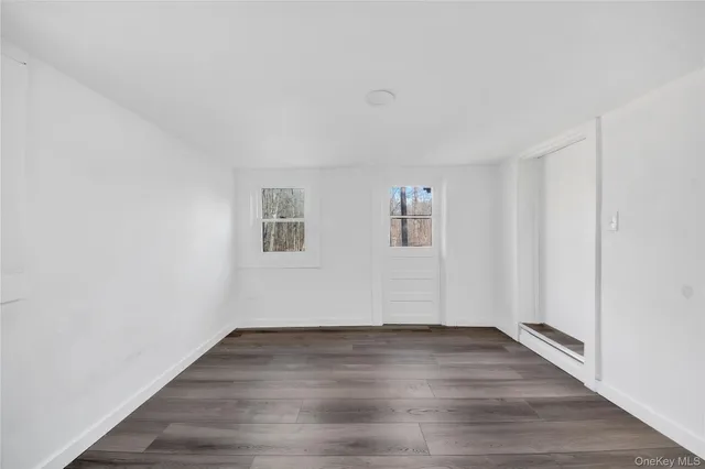 a view of empty room with wooden floor