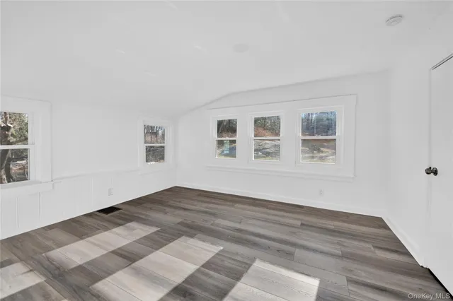 a view of a room with wooden floor and white walls