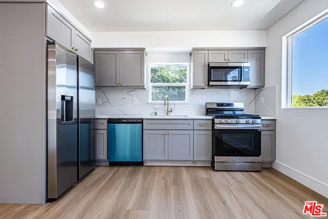 a kitchen with stainless steel appliances a stove microwave and sink