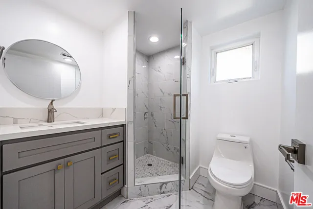 a bathroom with a toilet sink double vanity and mirror