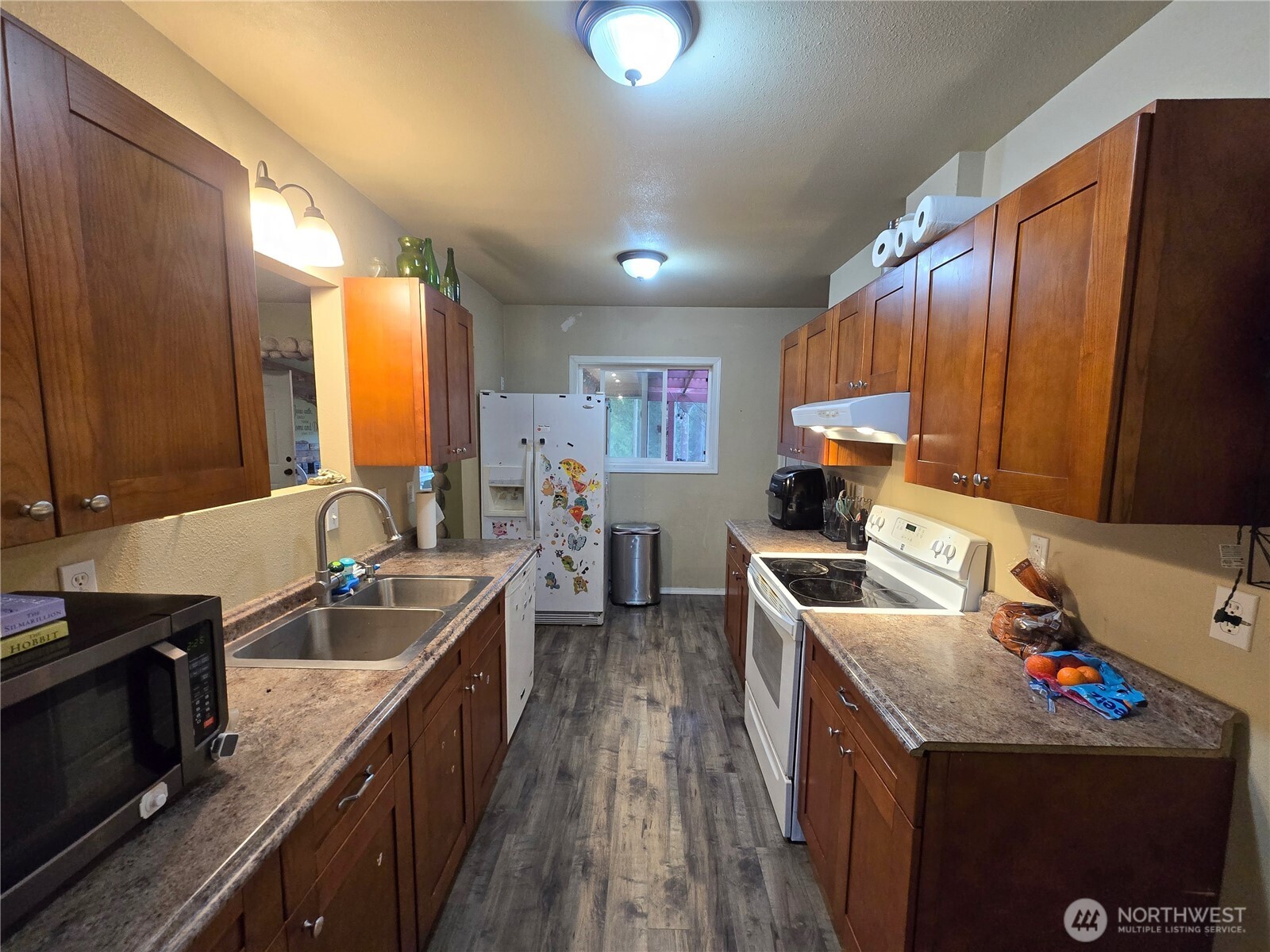 276261 Highway 101 Sequim, WA 98382 - Photo 15 of 33 a kitchen with granite countertop a sink stove and cabinets