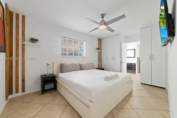 a spacious bedroom with a bed and a chandelier