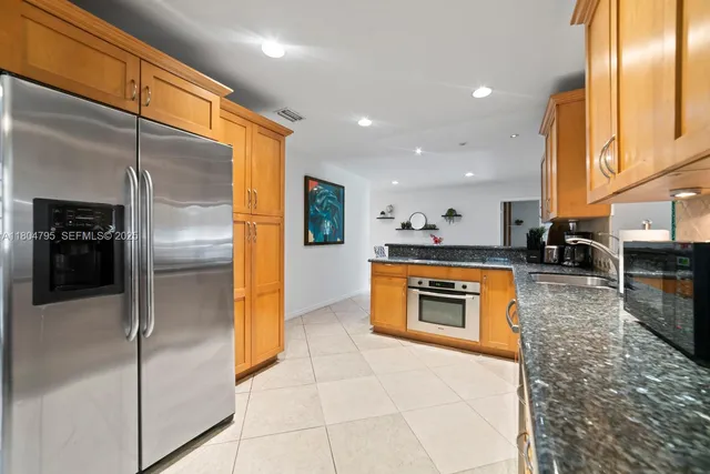 a kitchen with granite countertop stainless steel appliances and a refrigerator