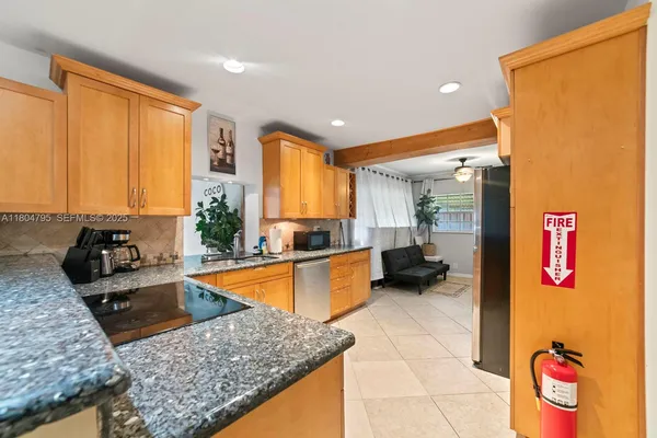 a kitchen with stainless steel appliances granite countertop a sink and a refrigerator