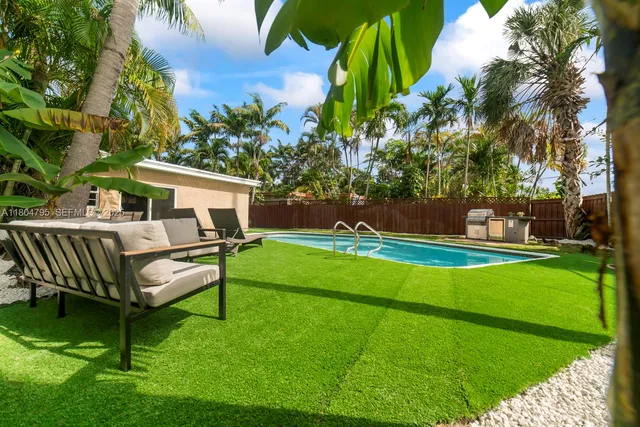 a view of a white house with a yard porch and sitting area