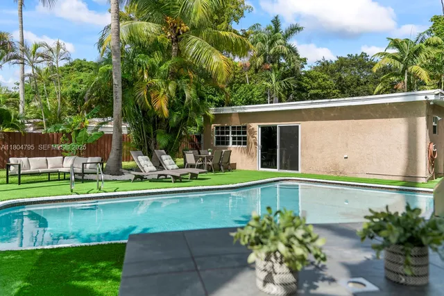 a view of house with a swimming pool and a garden
