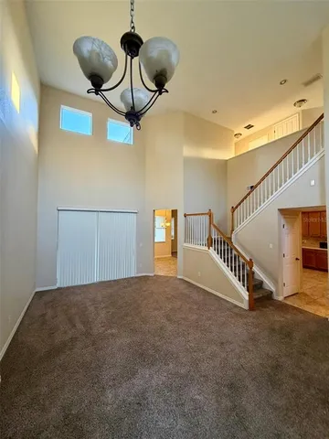 a view of a room with stairs and a chandelier