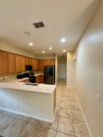 a view of kitchen with stainless steel appliances a sink counter top space and cabinets