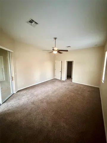 an empty room with an empty space and a ceiling fan