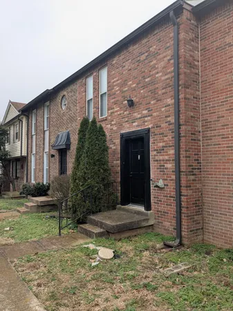 a view of a brick house with a yard