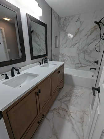 a bathroom with a double vanity sink mirror double and bathtub