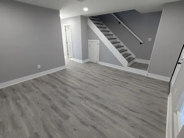 a view of an empty room with wooden floor