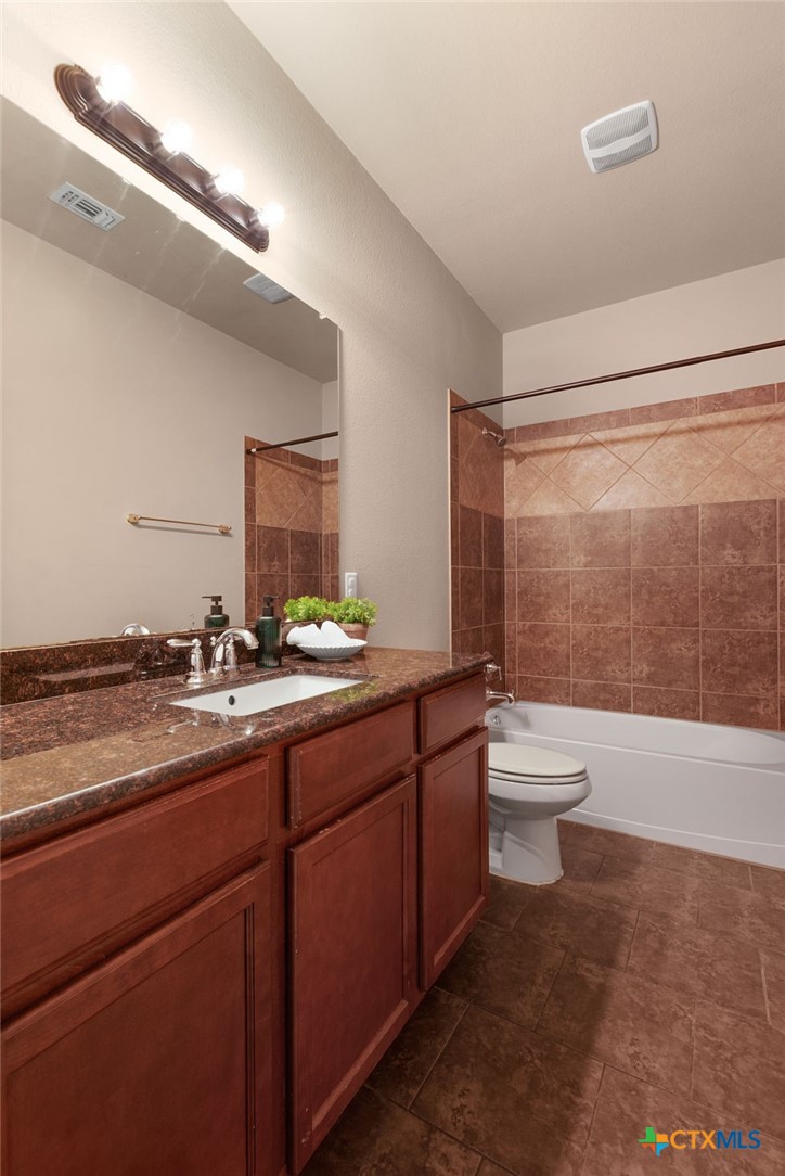 408 Copper Ridge Loop Temple, TX 76502 - Photo 27 of 39 Secondary bathroom with neutral tones, ample cabinet storage, and a tub/shower combo