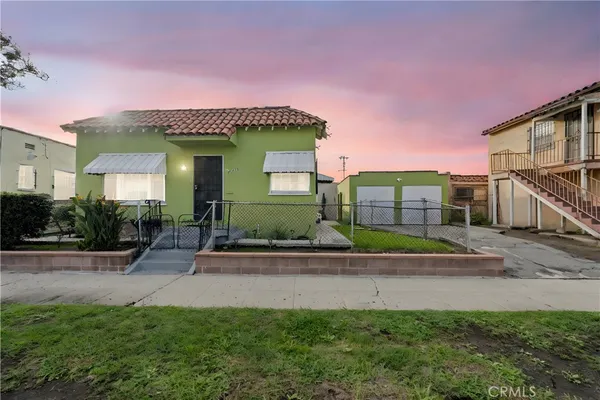 a front view of a house with a yard and potted plants