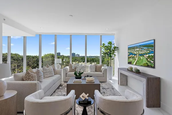 a living room with furniture potted plant and a large window